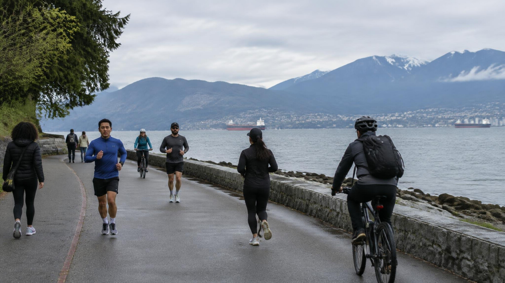 Pedestrian path along the Vancouver seawall with mountains in the background